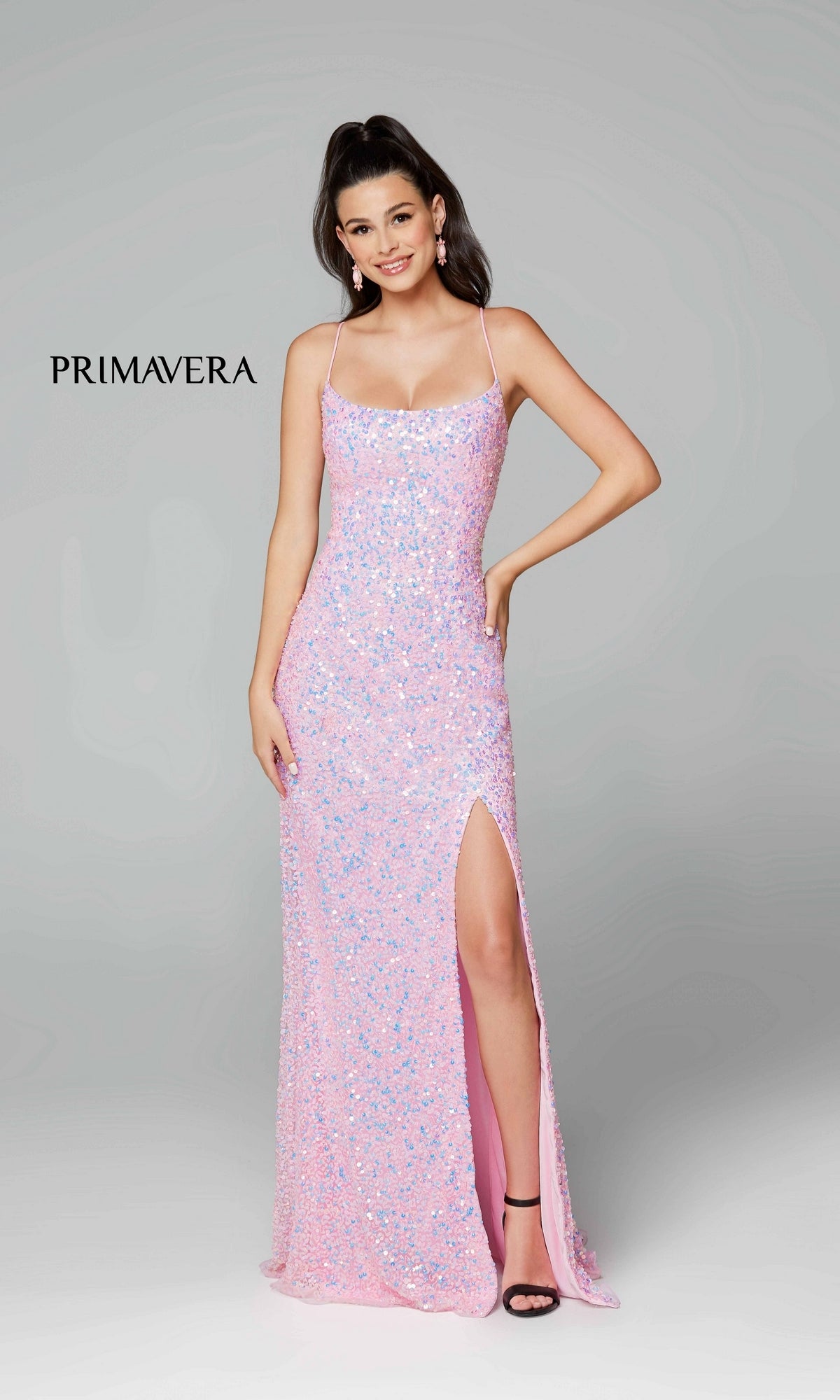 A woman poses against a plain gray background in the Strappy-Back Pastel Long Sequin Prom Dress 3290, featuring spaghetti straps, a backless design, and a thigh-high slit. The word